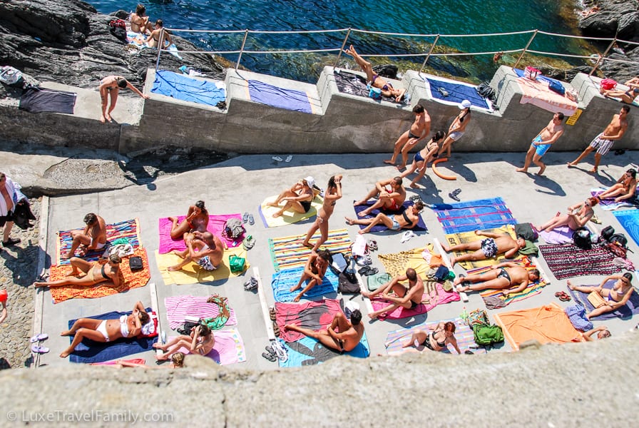 sunbathers on the boat ramp Manarola Italy