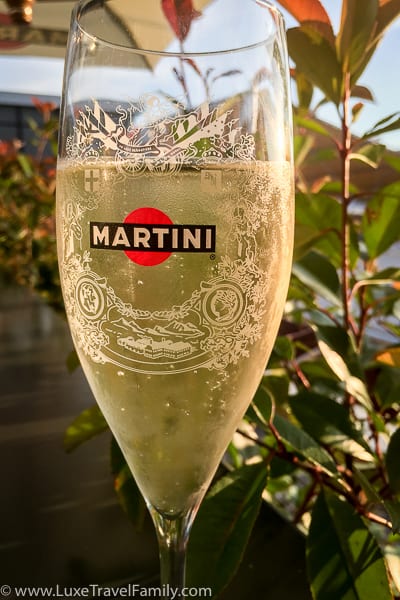 A glass of Prosecco with the Martini logo on the glass