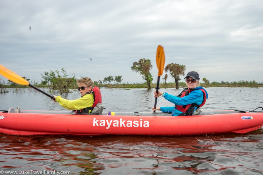 Family kayaking on Tonle Sap Lake with Smiling Albino