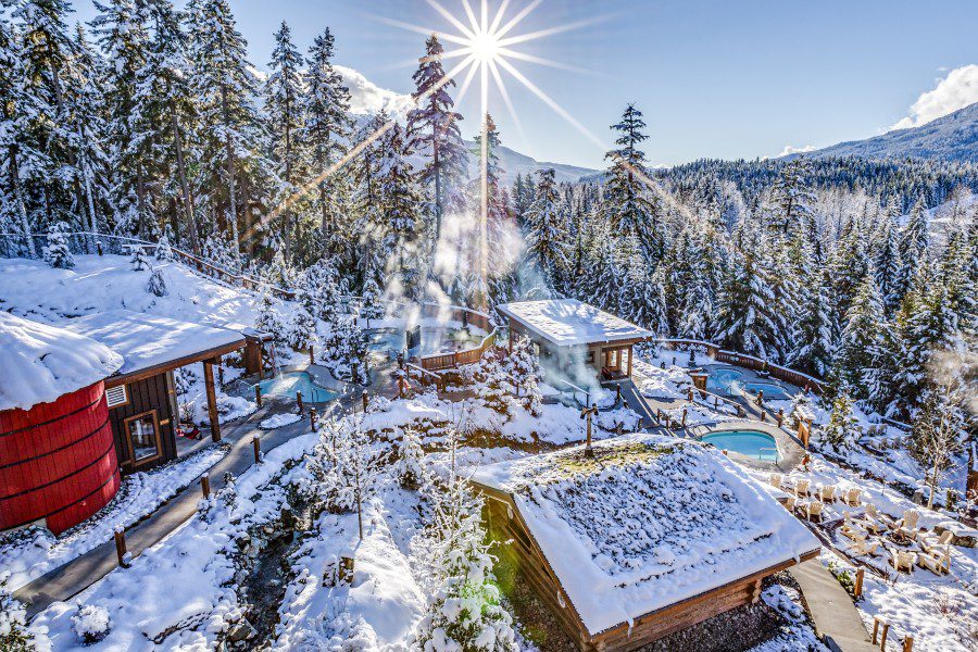 Scandinave Spa Whistler spa pools, snow-covered trees and buildings.