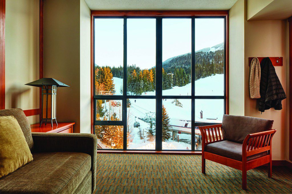 Sofa and chair in a one-bedroom suite overlooking a chair lift Pan Pacific Whistler Mountainside