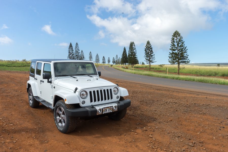 white jeep parked beside a paved two lane road
